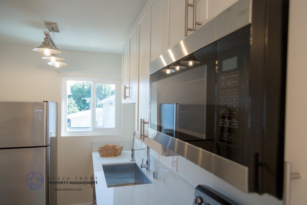 A modern kitchen with stainless steel appliances and white cabinetry.