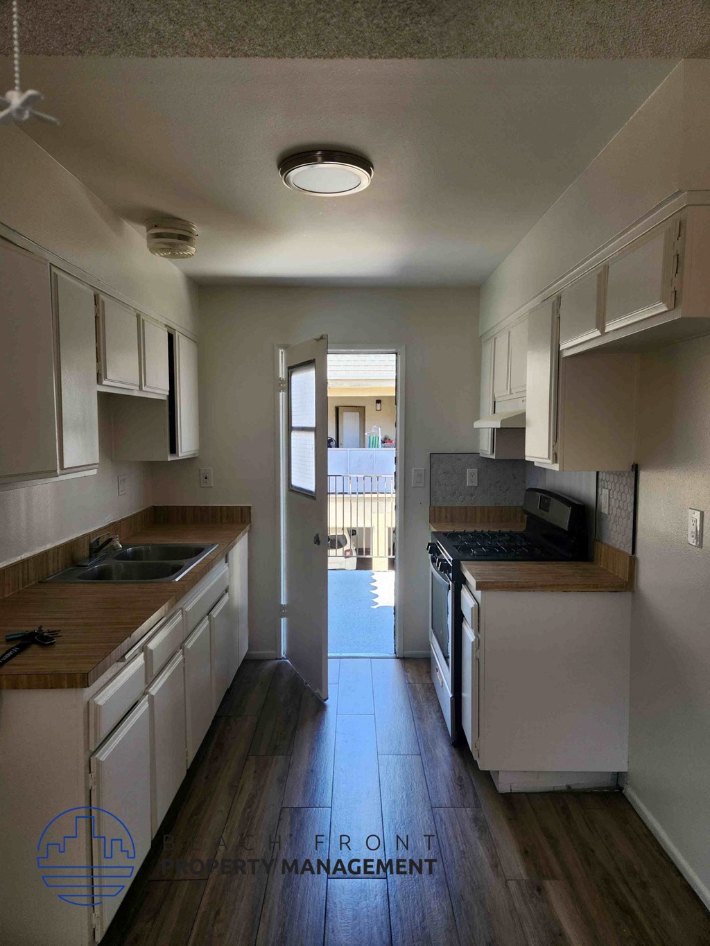A kitchen with white cabinets and a wooden counter top.