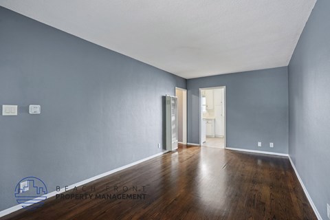 A spacious room with wooden floors and a white ceiling.