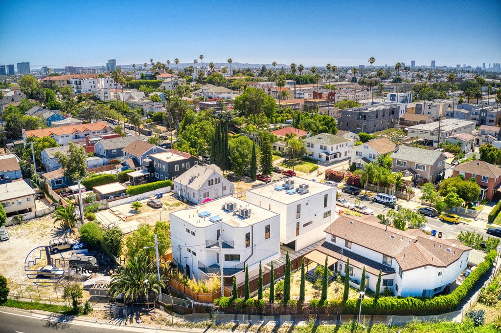 an aerial view of houses in a neighborhood with a city in the background