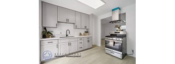 A modern kitchen with a stainless steel oven and white cabinets.