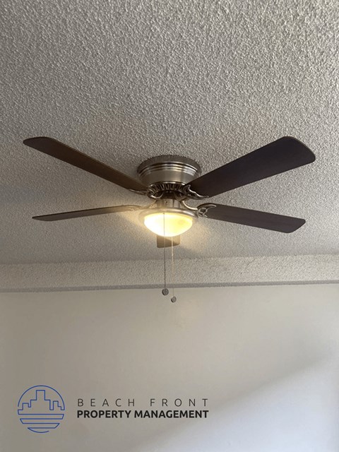 a ceiling fan with a light hanging from a ceiling