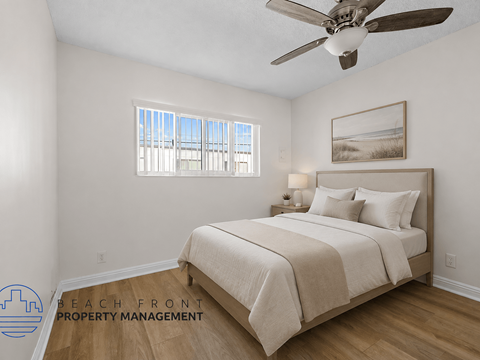 A bedroom with a large bed and a ceiling fan.