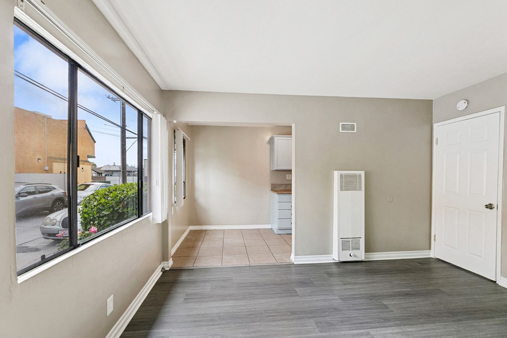 a living room with a large window and a door to a kitchen