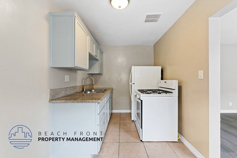 A kitchen with a white fridge and a white dishwasher.
