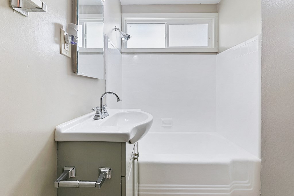 a small bathroom with a sink and a bath tub
