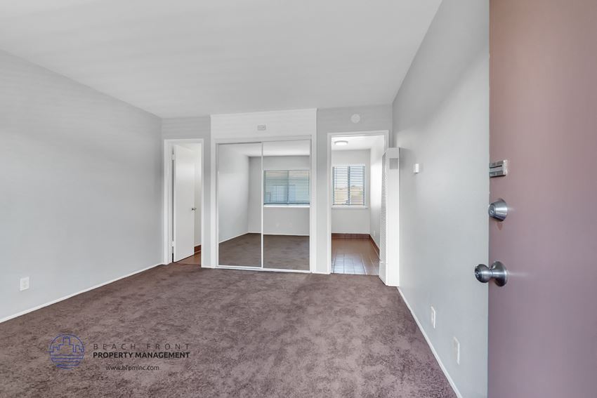a bedroom with white walls and a carpeted floor