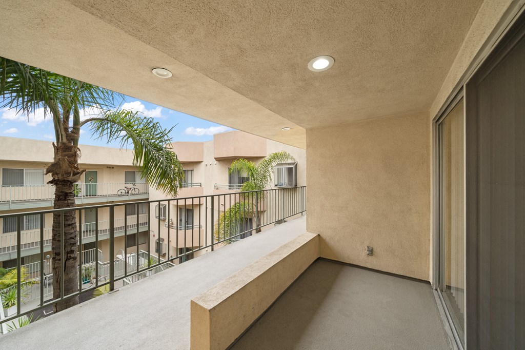 a balcony with a view of a palm tree