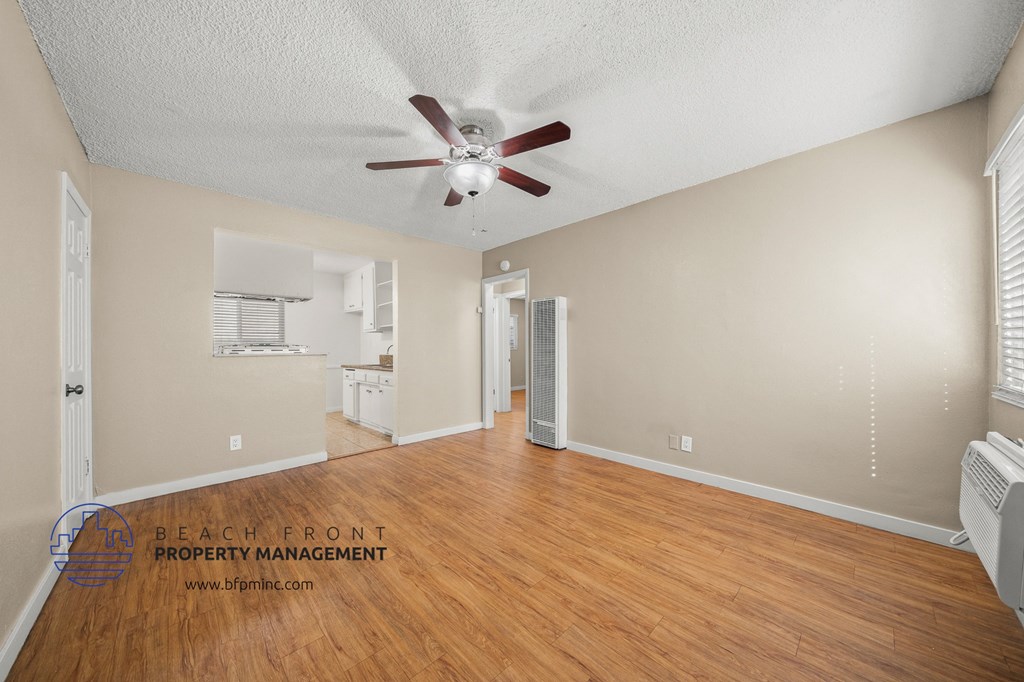 the living room and dining room with hardwood flooring and a ceiling fan