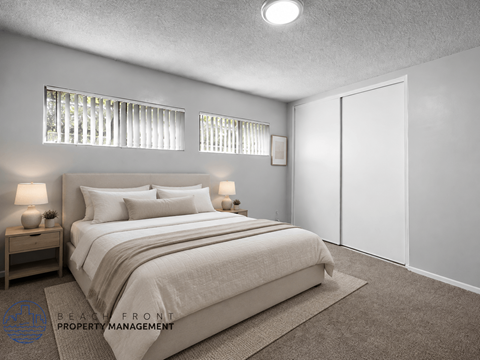 A bedroom with a large bed, two nightstands, and a carpeted floor.