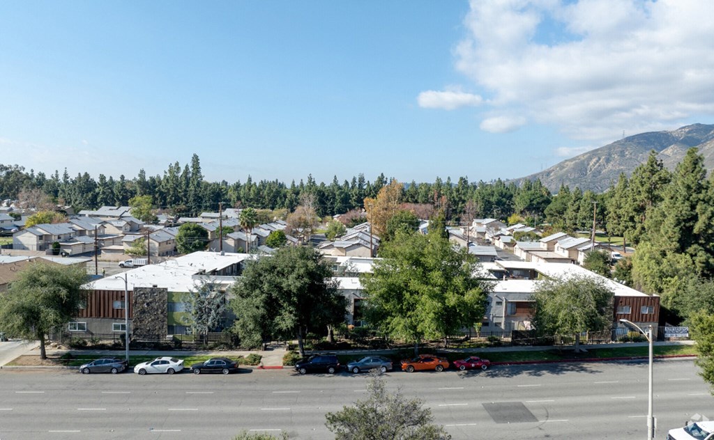 an aerial view of a parking lot in a city with houses and trees
