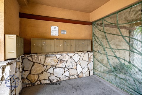 A room with a stone wall and electrical boxes.