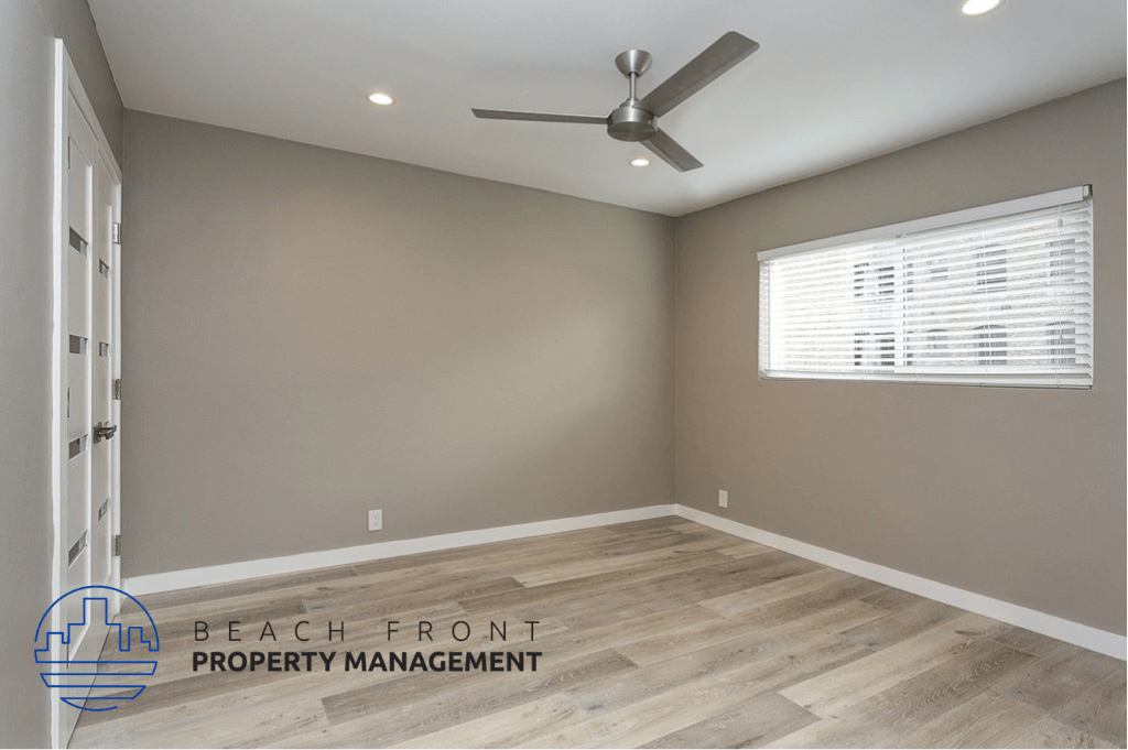 an empty room with a ceiling fan and a window