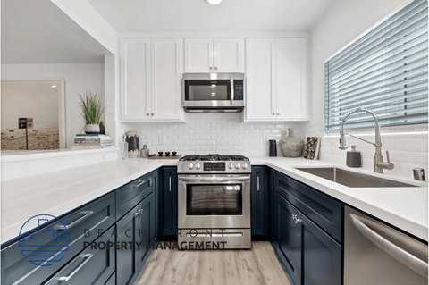 a kitchen with blue cabinets and white counter tops and a sink