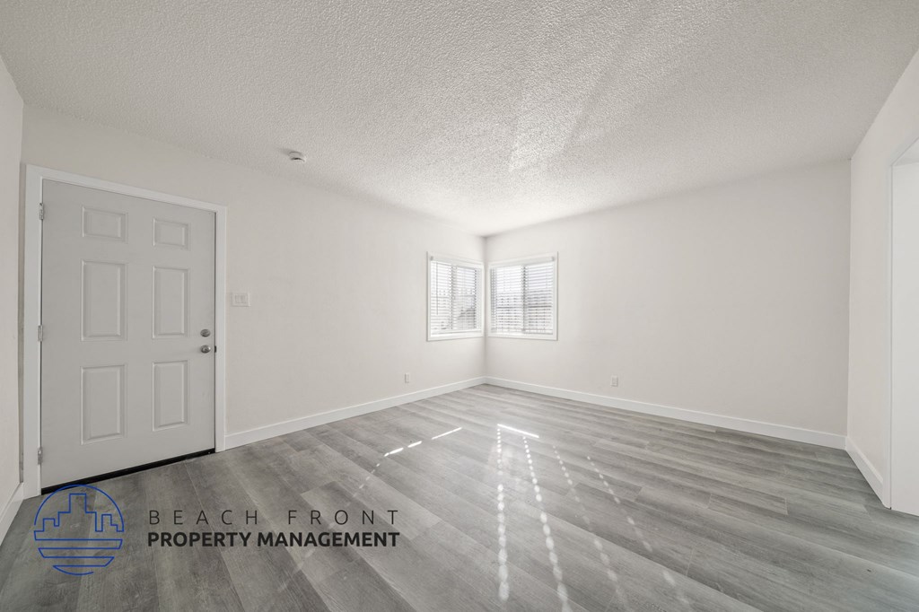 A room with a white door and a window with blinds.