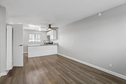A room with a ceiling fan and wooden flooring.