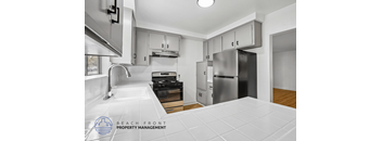 A kitchen with a stove top oven and a refrigerator.
