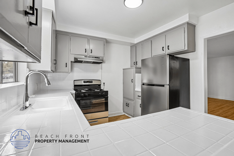 A kitchen with a stove top oven and a refrigerator.