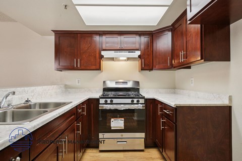 A kitchen with wooden cabinets and a stove top oven.