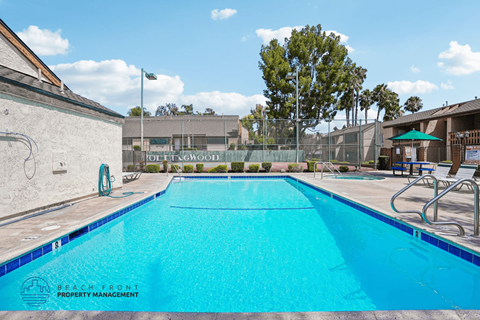 A swimming pool with a blue tiled edge and a white wall on the left.