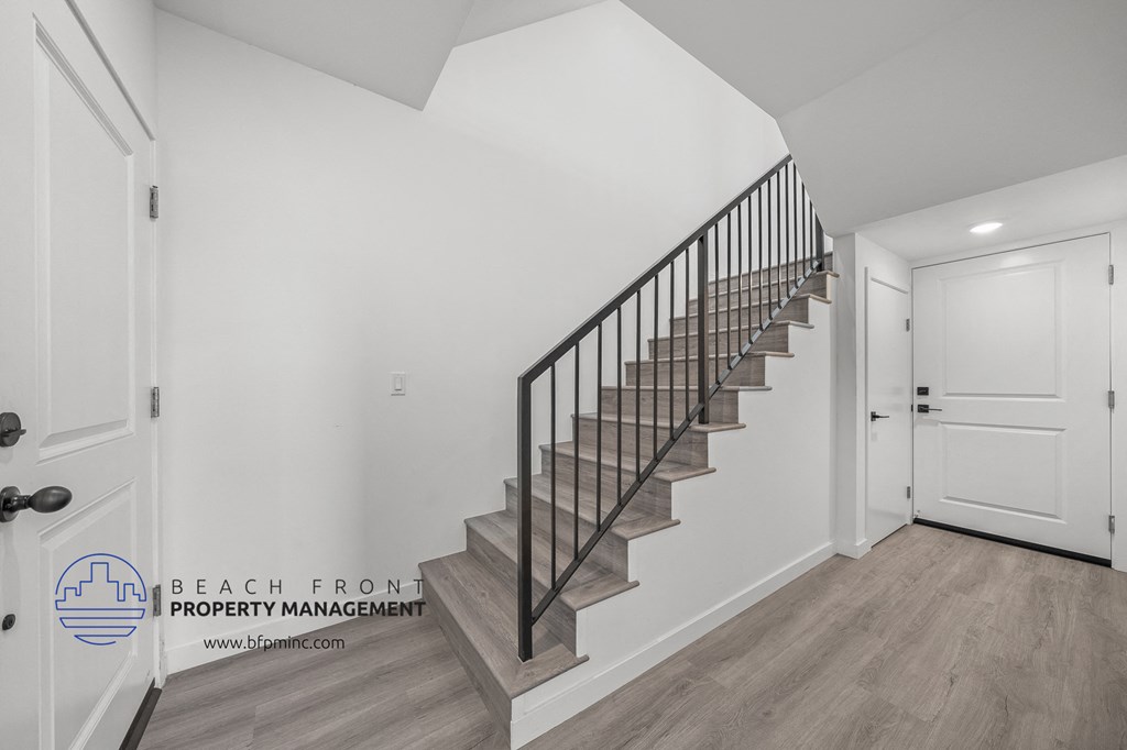 a stairwell in a home with white walls and a white door
