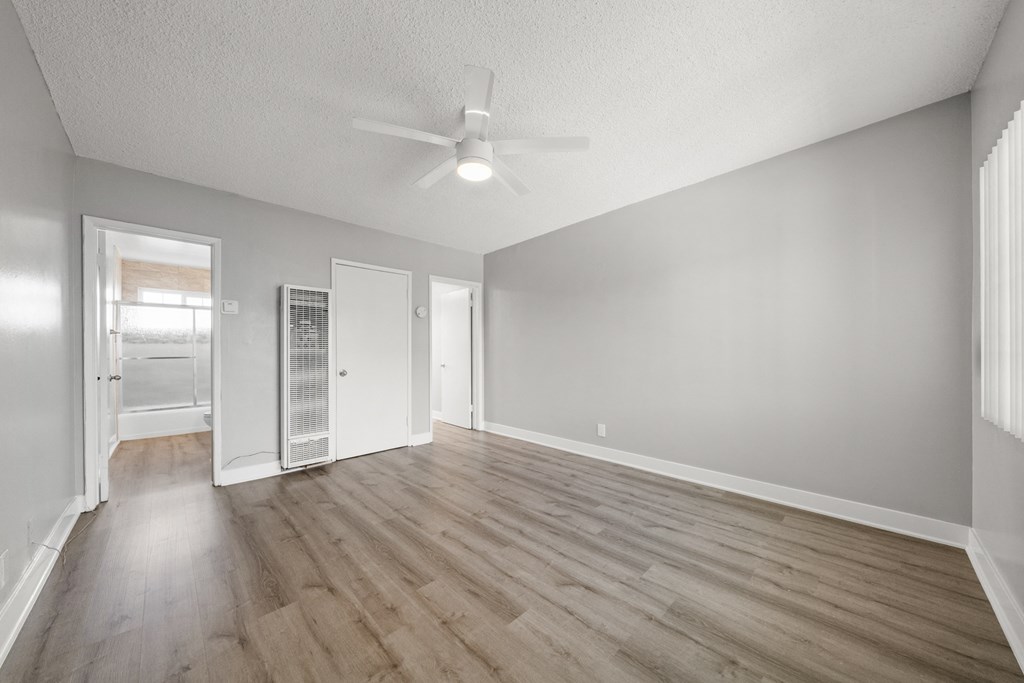 the living room of an empty house with a ceiling fan