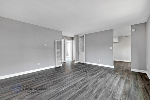 a renovated living room with grey and white walls and wood floors