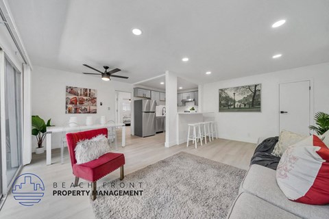 a living room with a couch and a chair in front of a kitchen