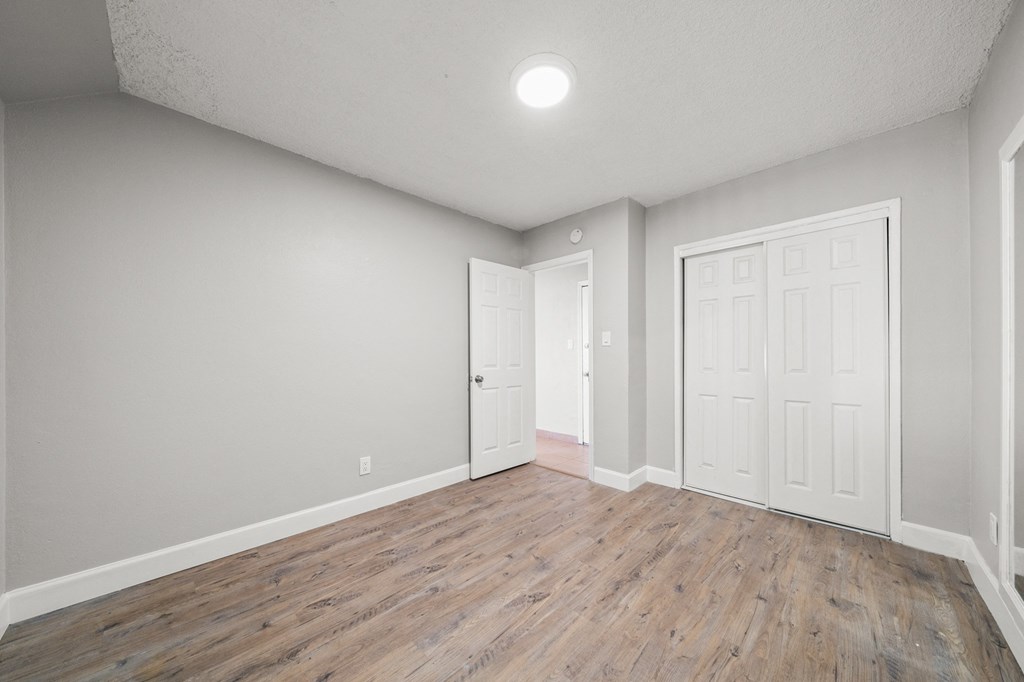 an empty living room with white walls and wood flooring