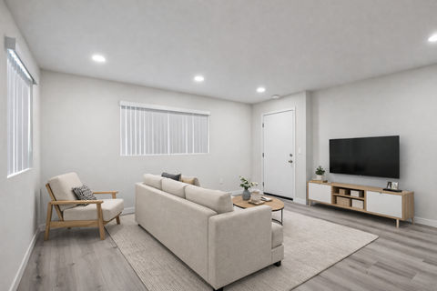 A living room with a couch, chair, and television.