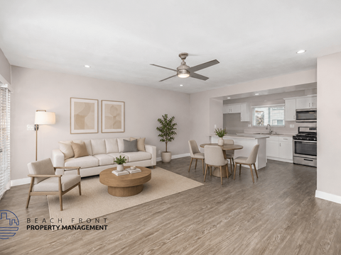 A living room with a white couch, a coffee table, and a dining table with chairs.