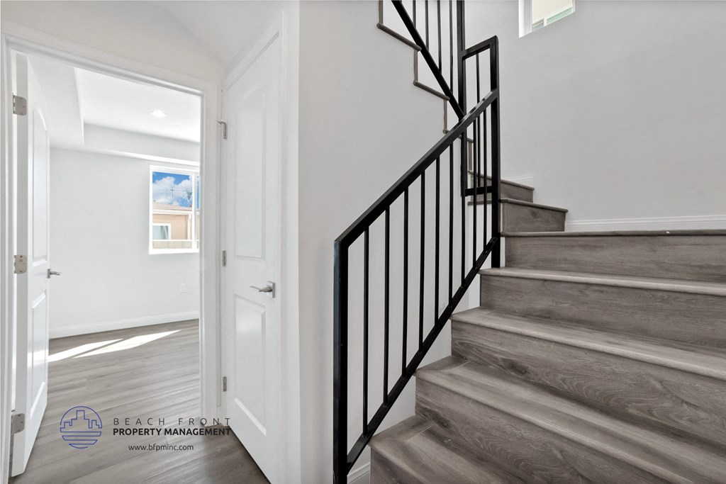 the landing of a staircase in a home with white walls and wood floors