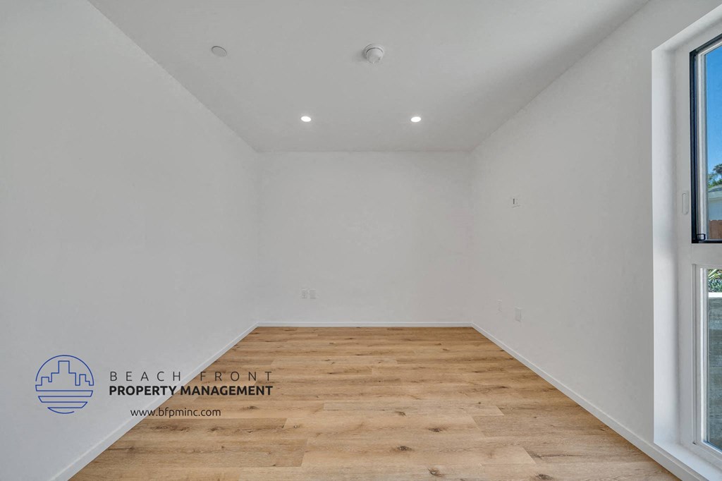 a room with a wood floor and a window