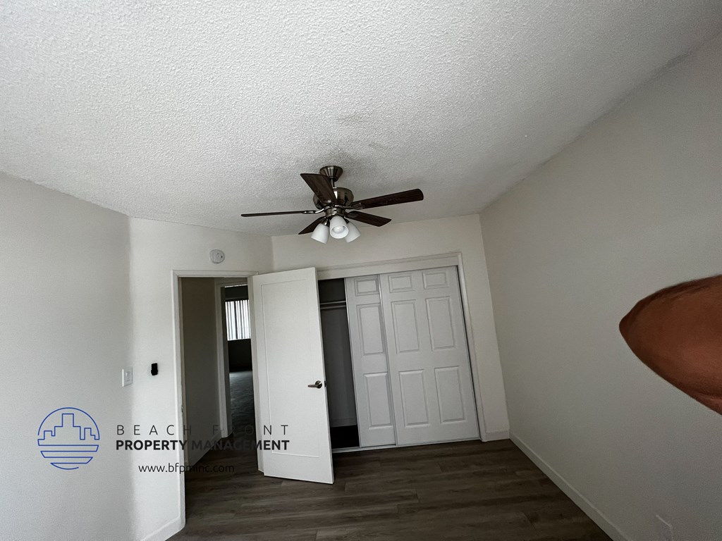 a bedroom with a ceiling fan and a door to the bathroom