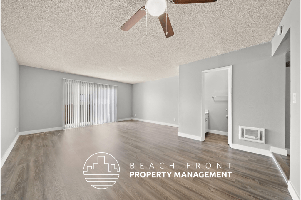 an empty living room with wood flooring and a ceiling fan