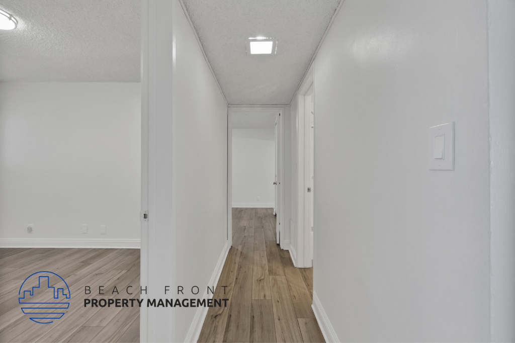 a renovated hallway with white walls and wood flooring
