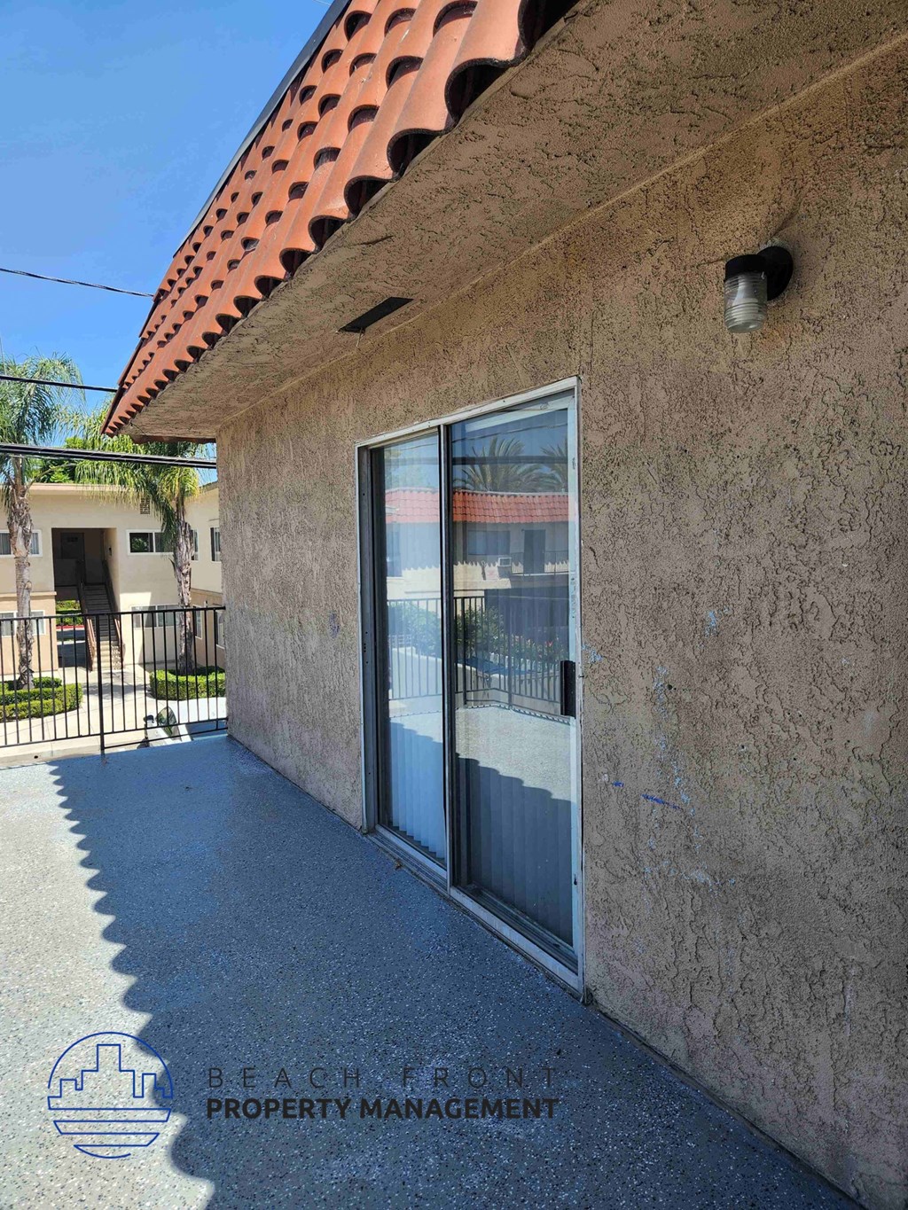 A building with a red tile roof and a wall with a window.