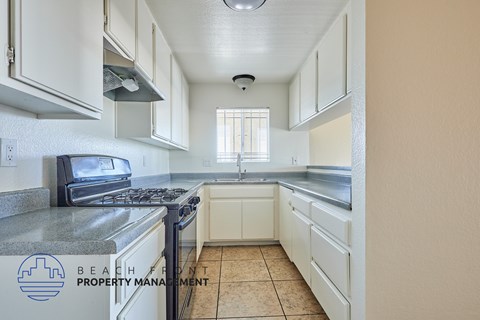 A kitchen with a stove top oven and a sink.