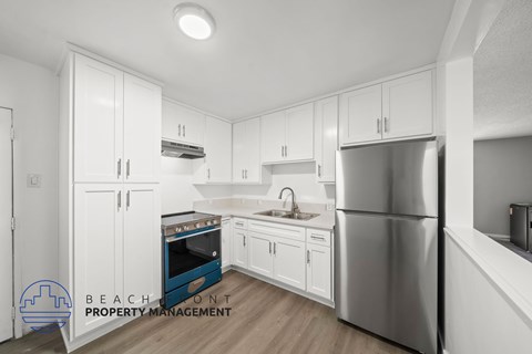 A kitchen with white cabinets and stainless steel appliances.