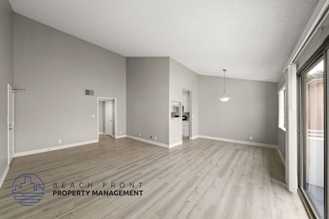 the living room and dining room with wood flooring and a large window