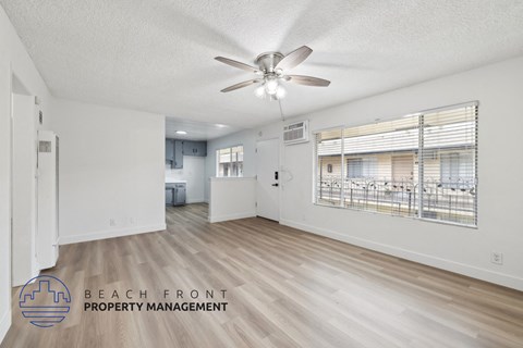 A spacious room with a ceiling fan and wooden flooring.