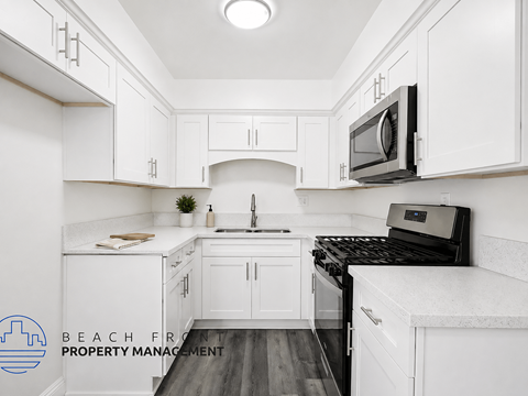 A kitchen with white cabinets and a black stove top oven.