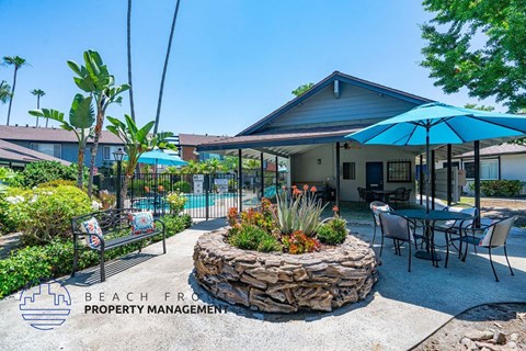 a patio with tables and umbrellas and a house