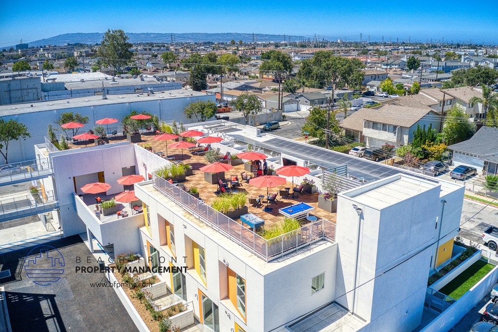 an aerial view of a white apartment building with a rooftop patio