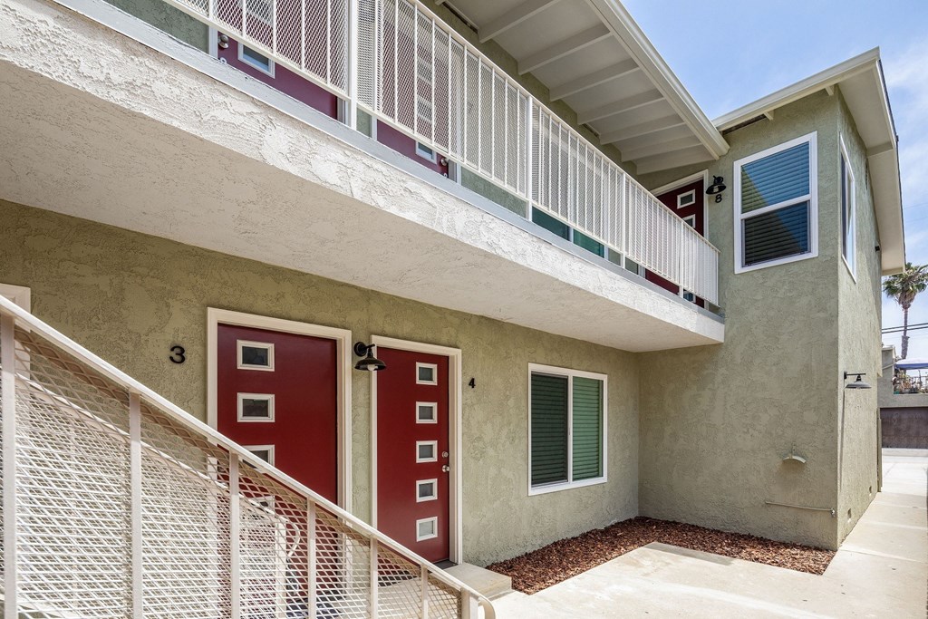 a building with a red door and a white balcony