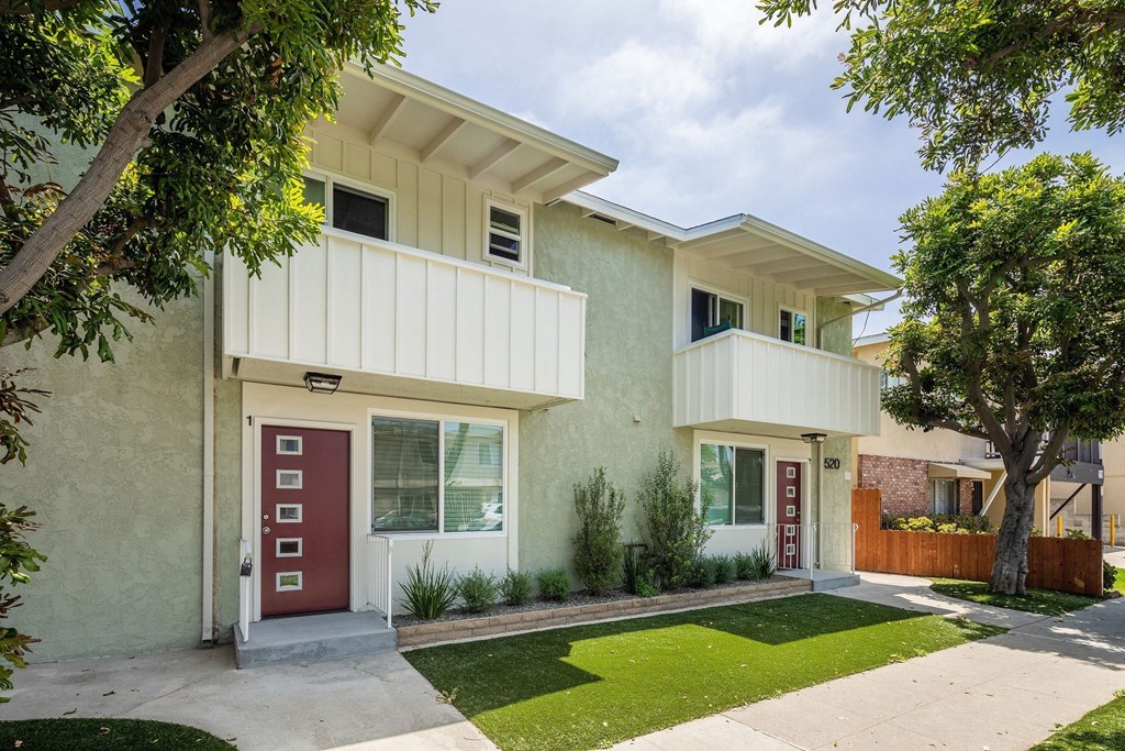 a building with two balconies and a red door