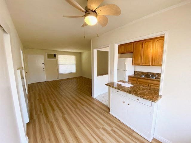 an empty kitchen and living room with a ceiling fan