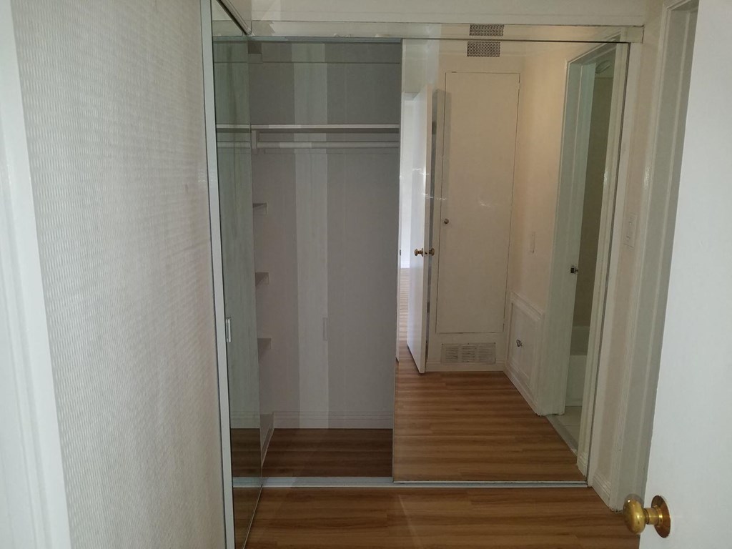 a hallway with a sliding glass door into a closet