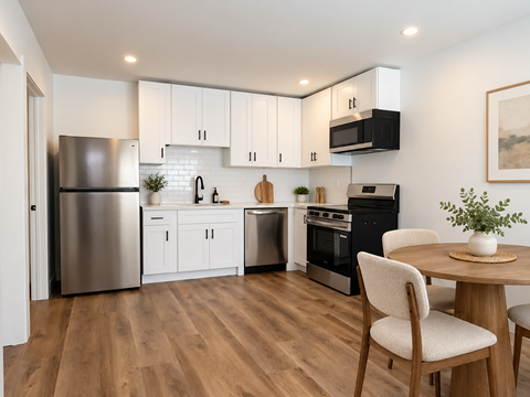A modern kitchen with wooden floors and stainless steel appliances.