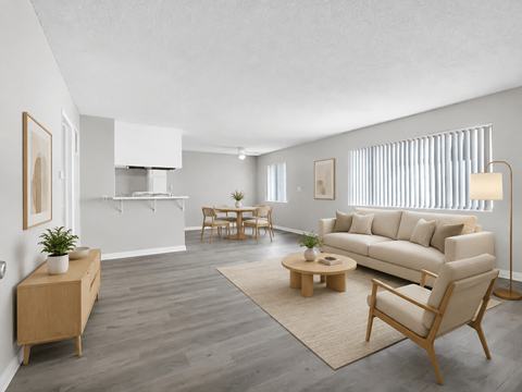A living room with a white couch, wooden furniture, and a rug.